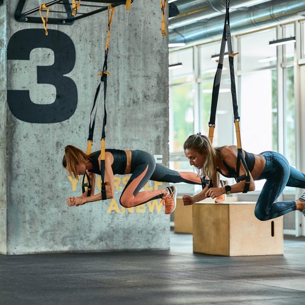 two-young-athletic-girls-exercising-with-trx-fitne-2022-01-19-00-15-27-utc_s